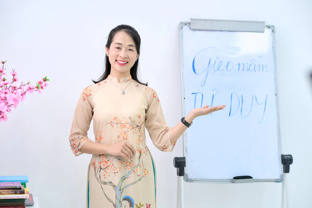 Chuyên gia Phạm Hoa bên bảng viết "Gieo mầm tư duy" trong buổi hướng dẫn chương trình Cùng Con Thay Đổi Hành Vi.